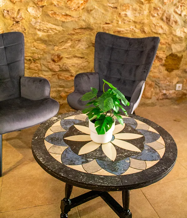 A reading corner at Sierra Recovery, two armchairs and a mosaic table against a stone wall