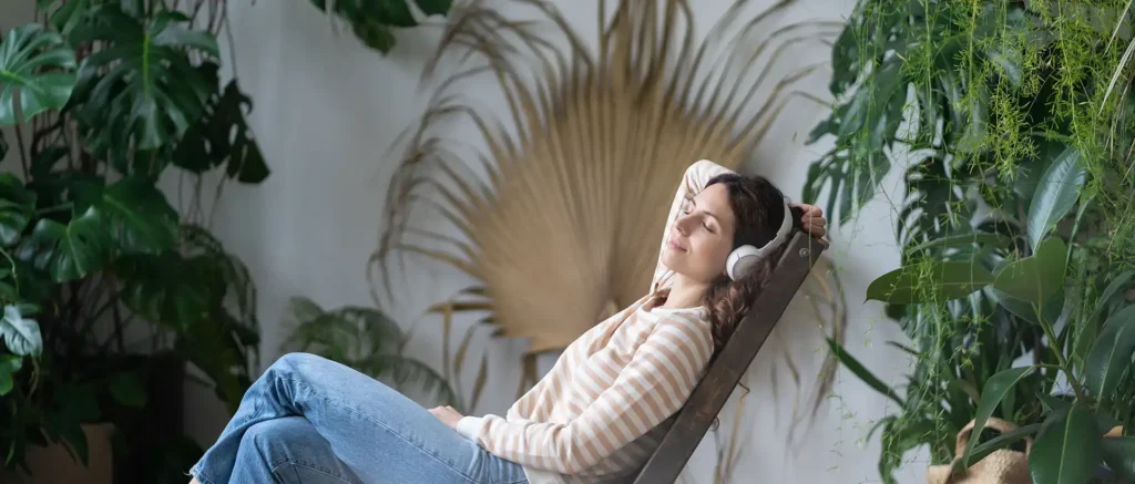 calm-young-female-daydreaming-wearing-earphones-harmony-plants-listening-music-audiobook