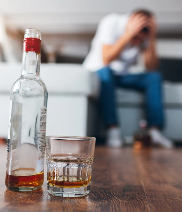 sierra recovery alcohol detox man sitting couch next bottle