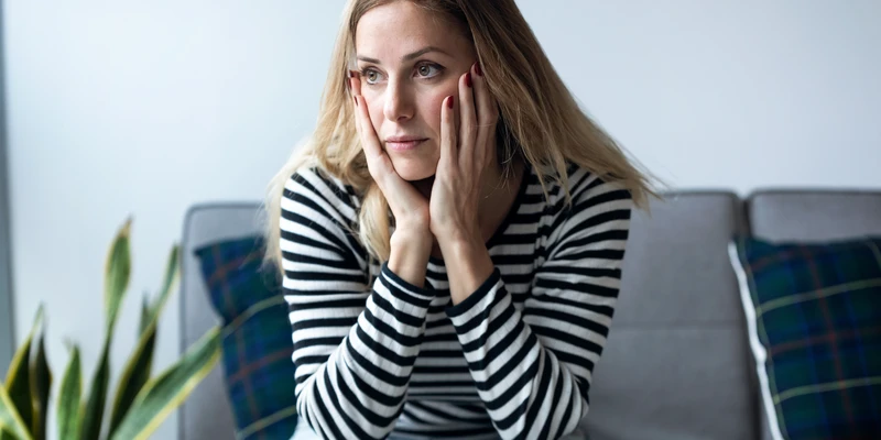 sierra recovery mental health woman sitting couch hand face