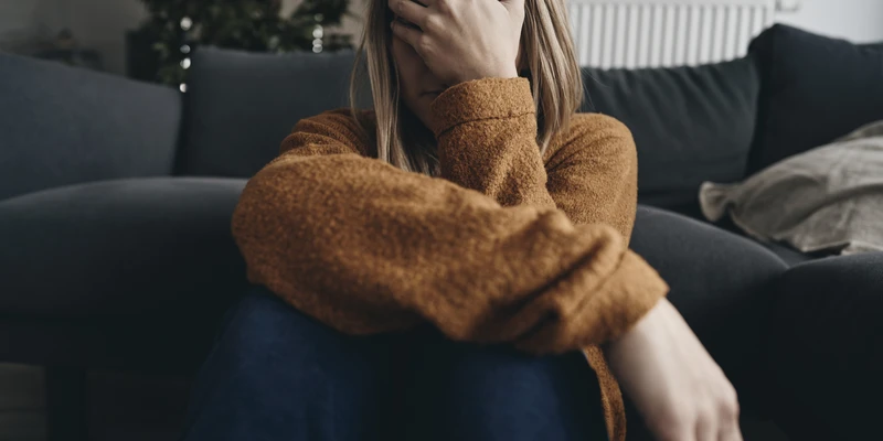 sierra recovery mental health woman sitting couch hand face