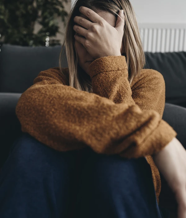 sierra recovery mental health woman sitting couch hands face