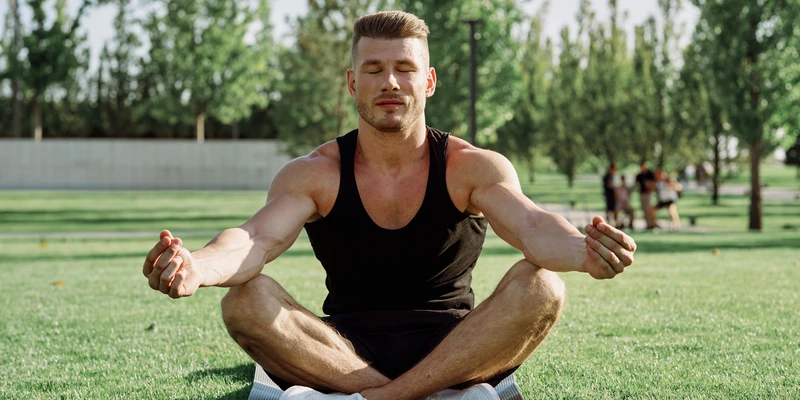 sierra recovery yoga man black tank top white shorts meditating
